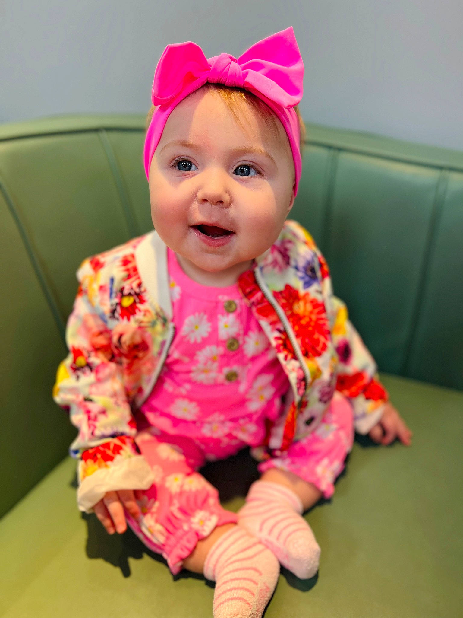 Carly is registered to the contest to win money with this photo: baby, baby_toddler_clothing, cap, cheek, child, face, facial_expression, fashion_accessory, fun, happy, headgear, headwear, magenta, pattern, peach, person, pink, sitting, skin, sleeve