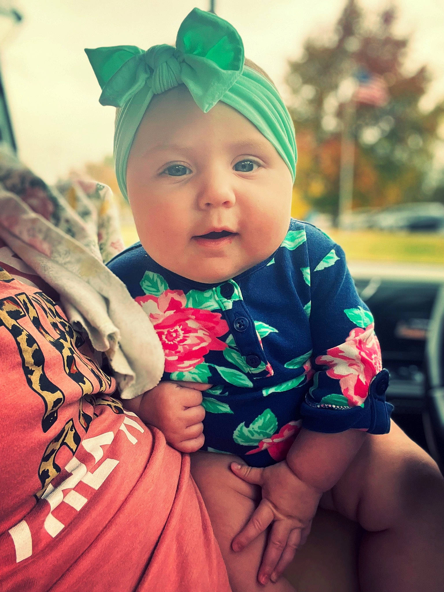 Carly is registered to the contest to win money with this photo: baby, baby_toddler_clothing, cap, child, cool, costume_hat, fashion_accessory, fun, grass, happy, headwear, jewellery, leisure, magenta, pattern, person, pink, sitting, skin, sleeve