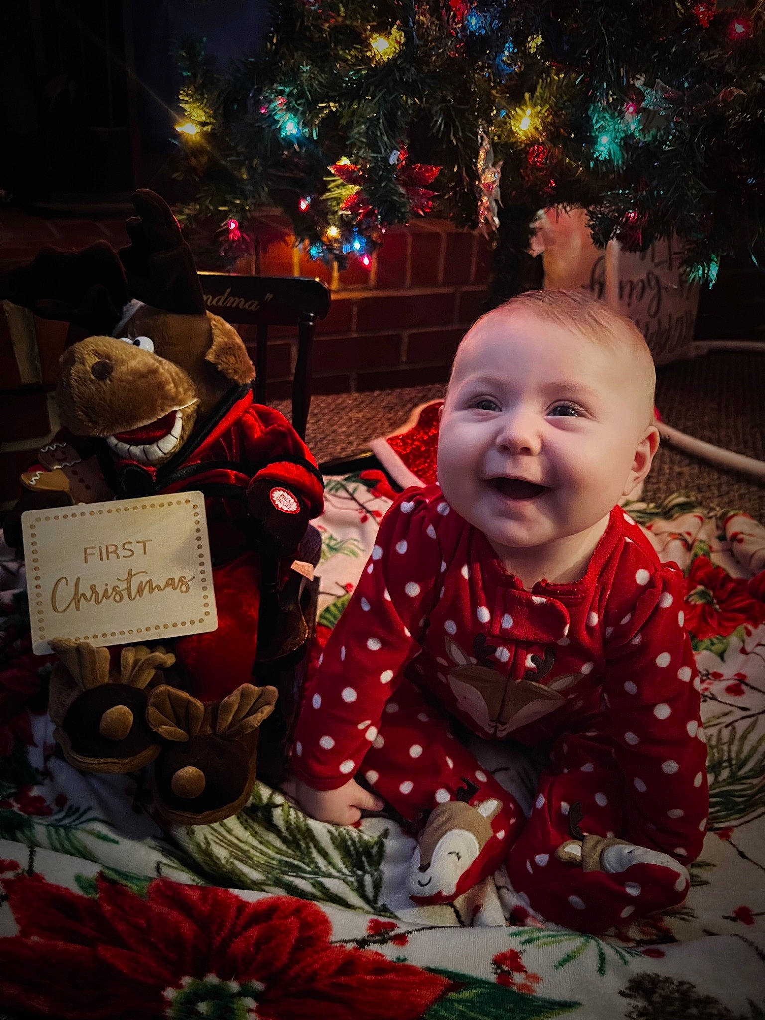 Carly is registered to the contest to win money with this photo: baby, christmas, christmas_decoration, christmas_eve, christmas_ornament, christmas_tree, event, happy, holiday, human_body, lighting, natural_foods, ornament, people, person, photograph, plant, red, smile, tree