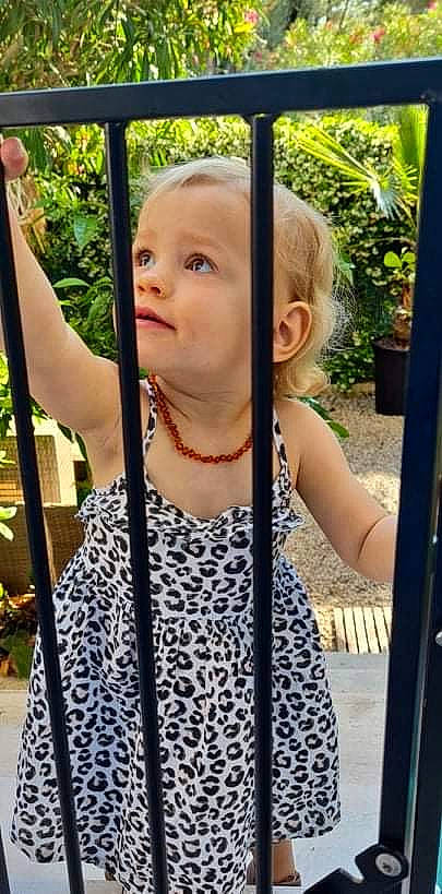 Tia participe au concours pour gagner de l'argent avec cette photo : baby_toddler_clothing, child, facial_expression, finger, fun, grass, happy, jewellery, leisure, neck, outdoor_play_equipment, pattern, person, plant, product, public_space, recreation, sleeve, summer, swing