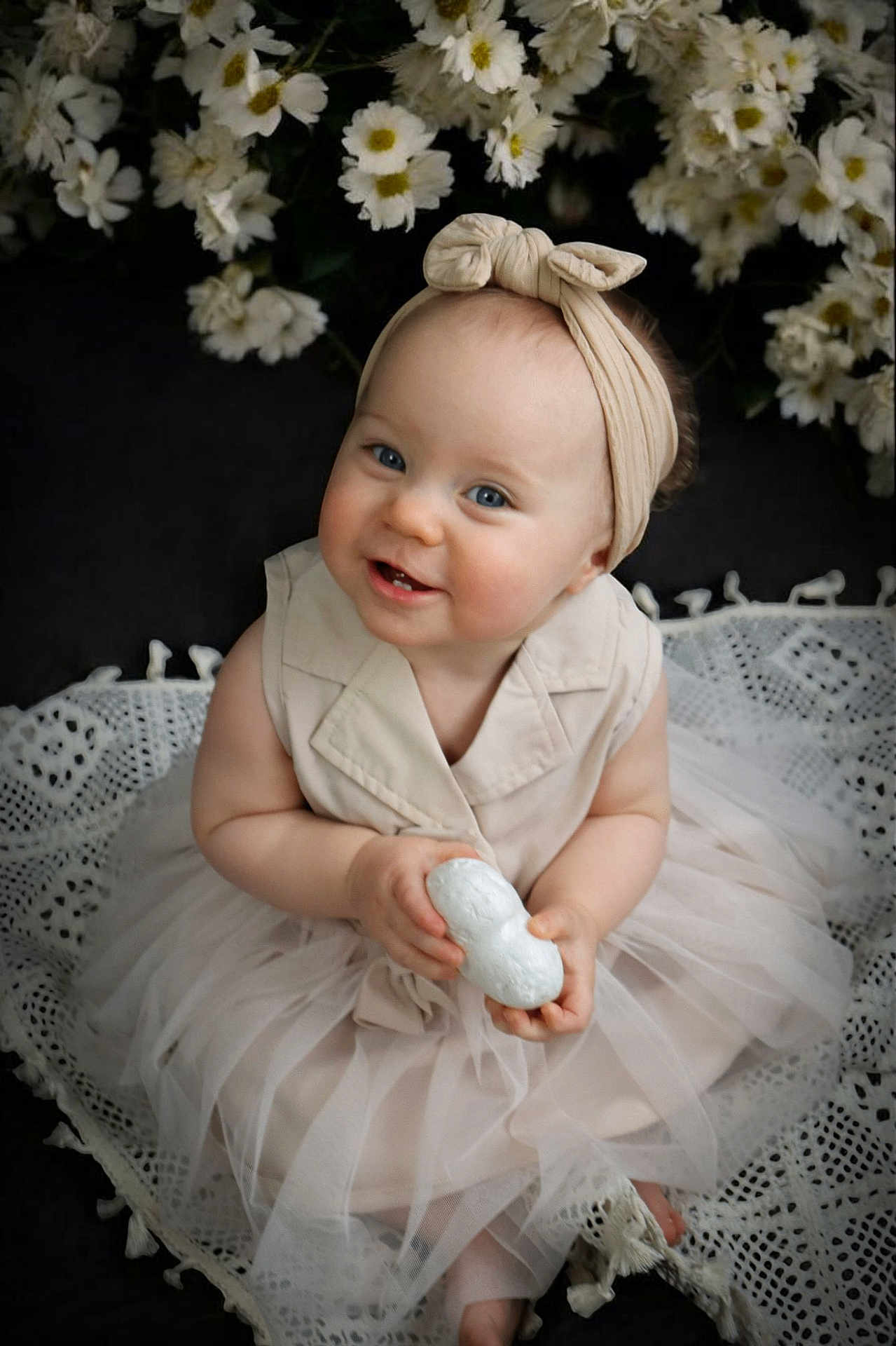 Juliana participe au concours pour gagner de l'argent avec cette photo : baby, child, smile, headband, blue_eyes, dress, tulle_skirt, flower, white_flower, lace_blanket, sitting, portrait, cute, indoor, infant, holding_object, soft_lighting, closeup, happy, adorable