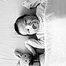 Tasho is registered to the contest to win money with this photo: baby, pacifier, blanket, bed, knitted_toy, bunny, sleeping, infant, black_and_white, soft_lighting, cute, child, portrait, indoors, resting, cozy, baby_clothes, toy, lying_down, peaceful