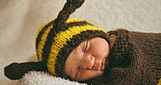 Tasho is registered to the contest to win money with this photo: baby, newborn, sleeping, knitted_hat, bee_costume, yellow, brown, soft_blanket, cute, infant, child, portrait, cozy, peaceful, resting, warm, closeup, face, headwear, sleep