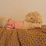 Tasho is registered to the contest to win money with this photo: baby, baby_clothing, beige, bunny_ears, child, chunky_blanket, cozy, cute, fluffy_tail, indoors, infant, knitted_diaper_cover, knitted_hat, lying_down, newborn, portrait, resting, sleepy, soft_texture, warm_colors
