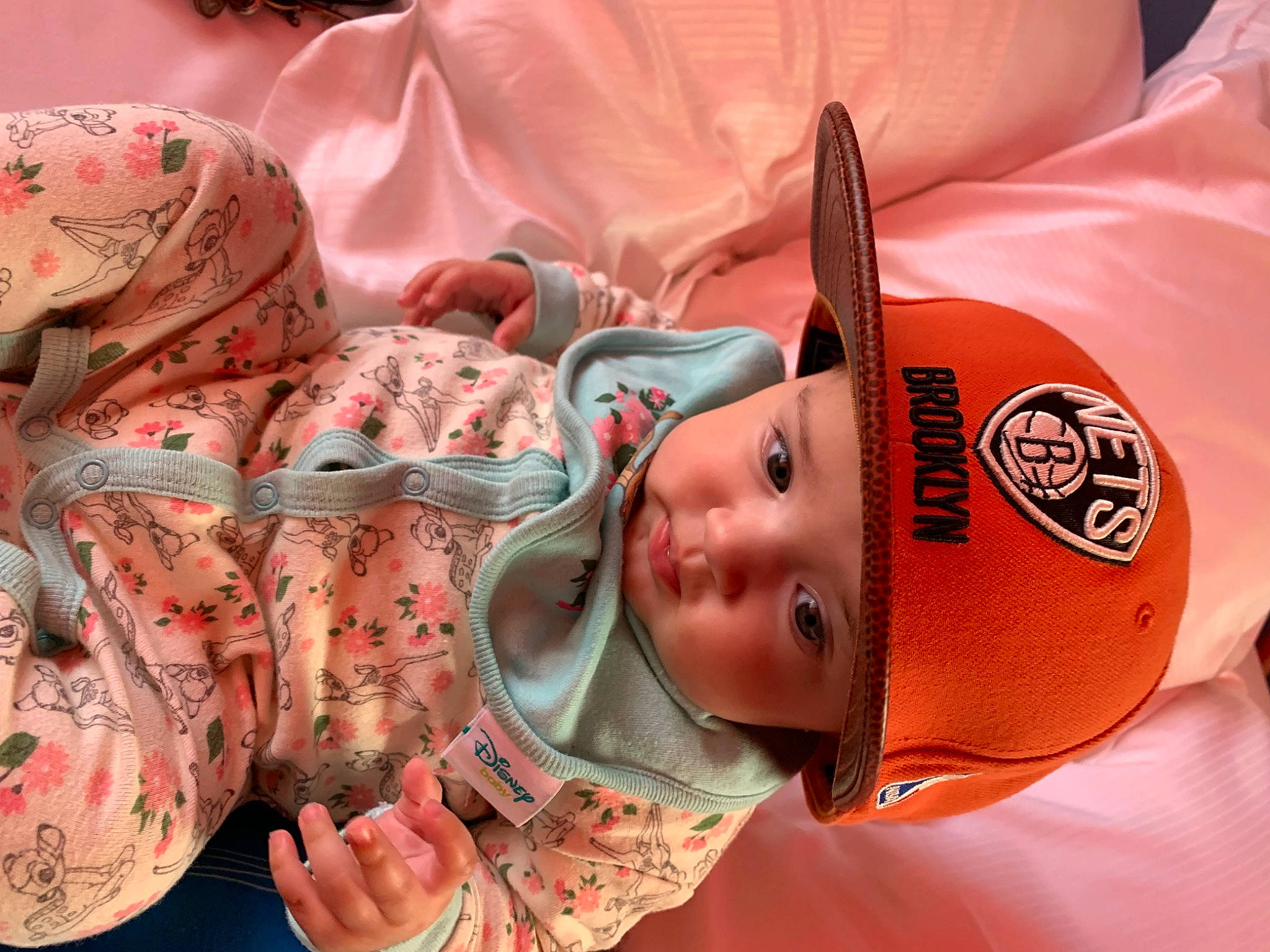 Zoé participe au concours pour gagner de l'argent avec cette photo : baby, baby_products, baby_toddler_clothing, carmine, cheek, child, comfort, fashion_accessory, flesh, headwear, linens, mammal, military_camouflage, mouth, orange, pattern, peach, person, pink, skin