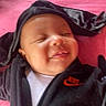 Salem is registered to the contest to win money with this photo: baby, smiling, infant, hoodie, black_clothing, nike_logo, pink_background, closeup, sleeping, face, child, cute, apparel, youth, portrait, happy, soft, cozy, resting, person