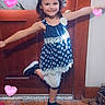 Rosaleen is registered to the contest to win money with this photo: blue_dress, carpet, child, decorative_hearts, door, floor_rug, girl, happy, heart_graphics, home_interior, indoor, long_hair, patterned_rug, playful, pose, smiling, sneakers, standing, white_leggings, wooden_door