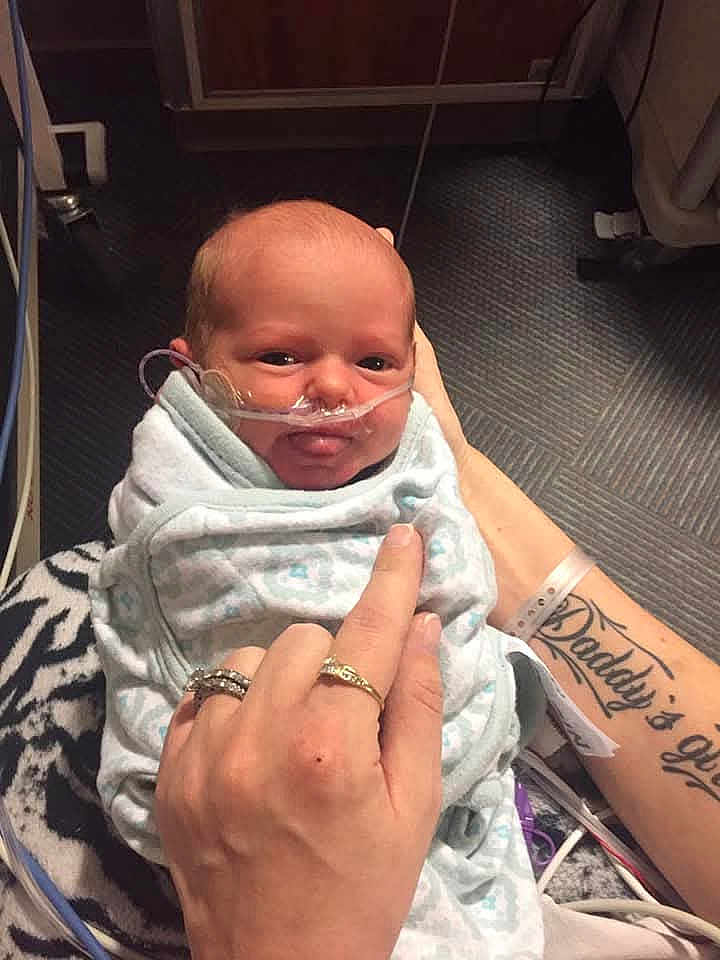 Rosaleen joined the competition — help win amazing prizes! baby, infant, blanket, nasal_tube, hand, rings, tattoo, hospital, medical_equipment, floor, person, swaddled, newborn, care, healthcare, indoor, closeup, holding, parent, comfort