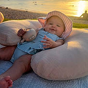 Oaklee joined the competition — help win amazing prizes! baby, infant, beach, sunset, pillow, hat, toy, smile, chubby, ocean, sand, water, blanket, portrait, outdoors, golden_hour, relaxation, cute, sunlit, family