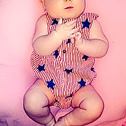 Octavia is registered to the contest to win money with this photo: baby, infant, child, headband, bow, blanket, pink, clothing, striped, stars, hands, feet, cute, portrait, lying_down, fabric, soft, indoors, skin, expression