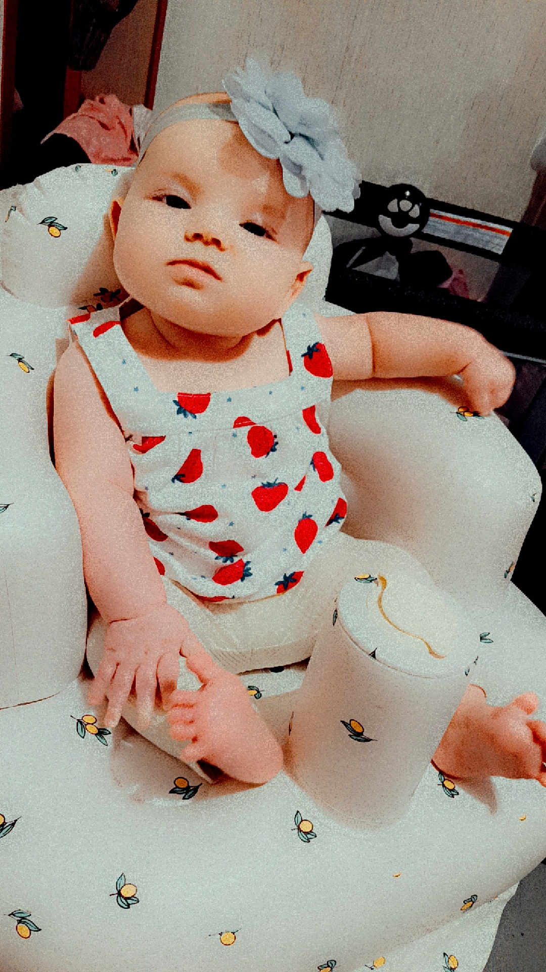 Octavia joined the competition — help win amazing prizes! baby, child, infant, headband, flower, strawberry_pattern, baby_chair, cushion, foot, hand, clothing, indoor, furniture, person, cute, seated, looking_at_camera, soft_lighting, skin, expression