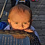 Matteo joined the competition — help win amazing prizes! toddler, child, face, eyes, hands, table, wicker, glass, outdoor, wooden_deck, toy, sunlight, shadow, curious, peek, baby, playful, green_eyes, close_up, daylight