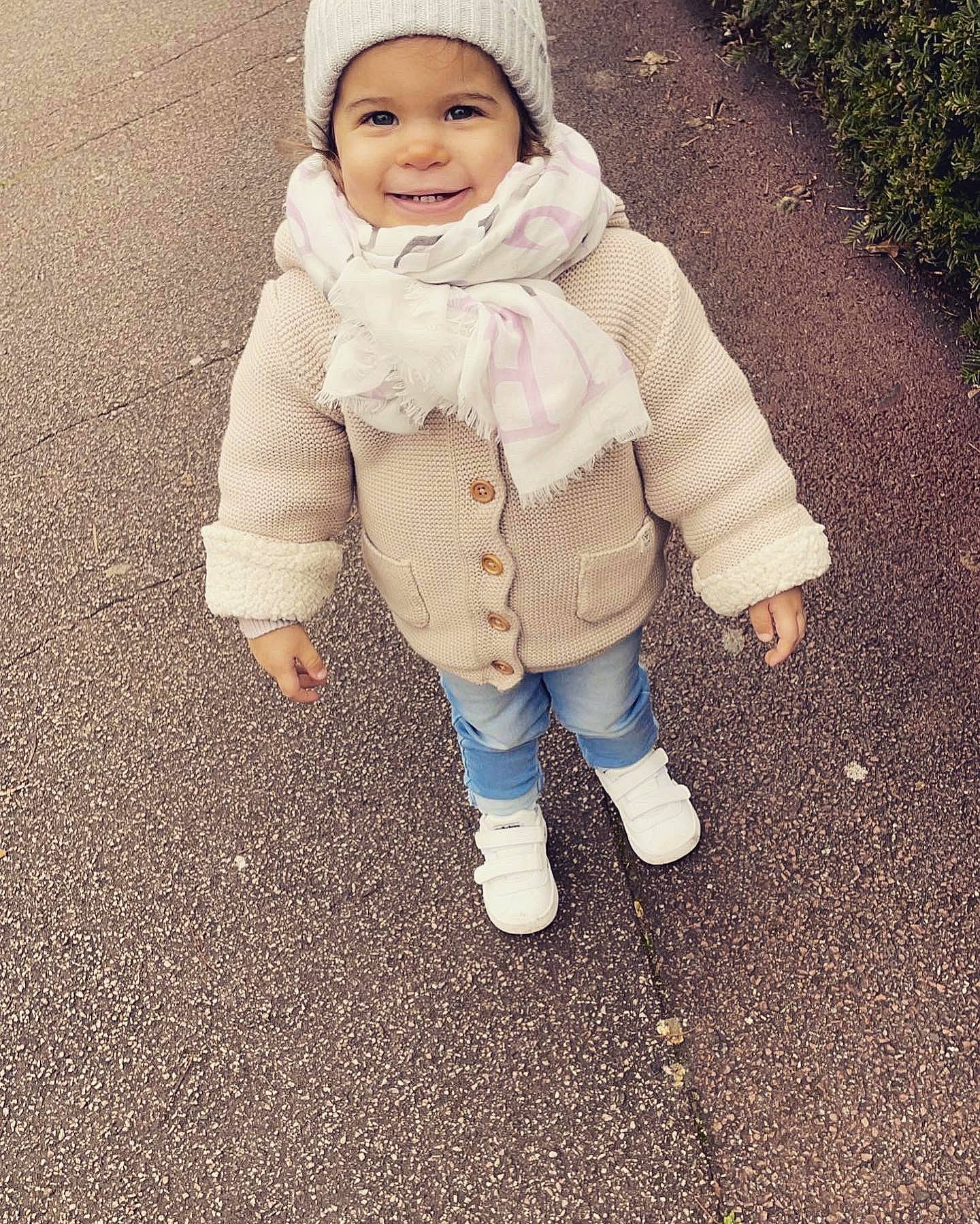 Myä a rejoint le concours — aidez-le/la à gagner de superbes lots ! arm, asphalt, baby, baby_toddler_clothing, cap, eye, face, gesture, grass, happy, head, headwear, human_body, joy, leg, people_in_nature, person, sleeve, smile, thumb