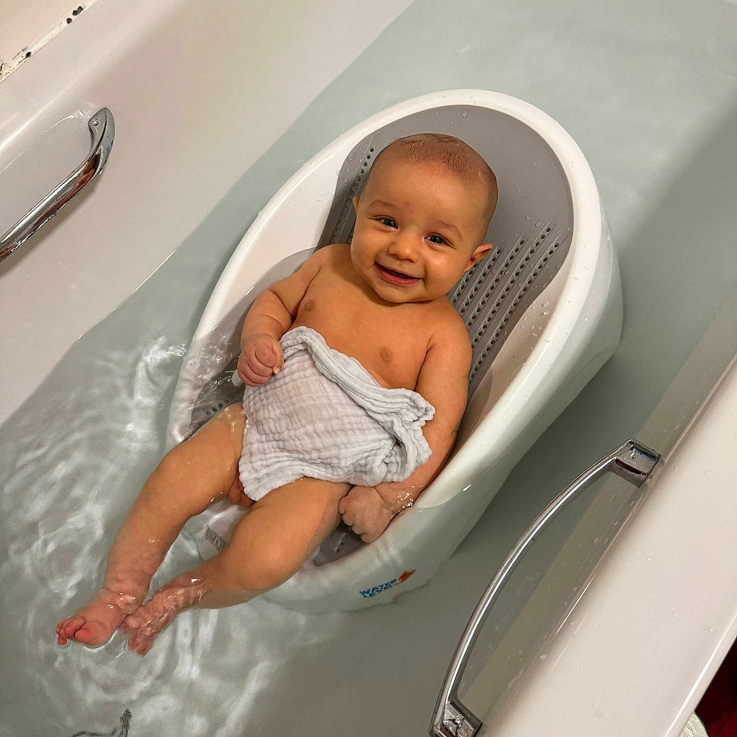 Elius is registered to the contest to win money with this photo: baby, bathing, bathtub, crib, cup, diaper, face, furniture, happy, head, infantbed, newborn, person, photography, portrait, smile, tub