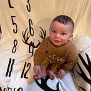Stetson is registered to the contest to win money with this photo: baby, child, sitting, sweater, blanket, numbers, antlers, cozy, cute, indoor, feet, face, head, expression, person, knitwear, soft, comfort, young, portrait