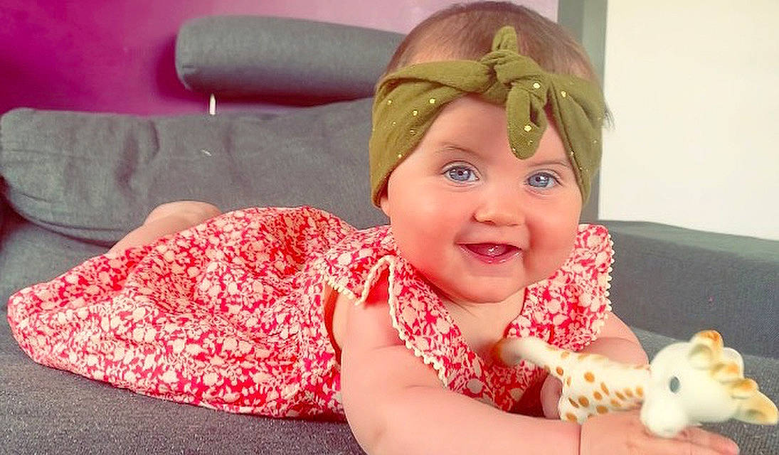 Carmen a rejoint le concours — aidez-le/la à gagner de superbes lots ! baby, baby_laughing, child, ear, fashion_accessory, hair_accessory, head, headband, headgear, headpiece, headwear, joy, person, pink, play, smile, toddler, tummy_time