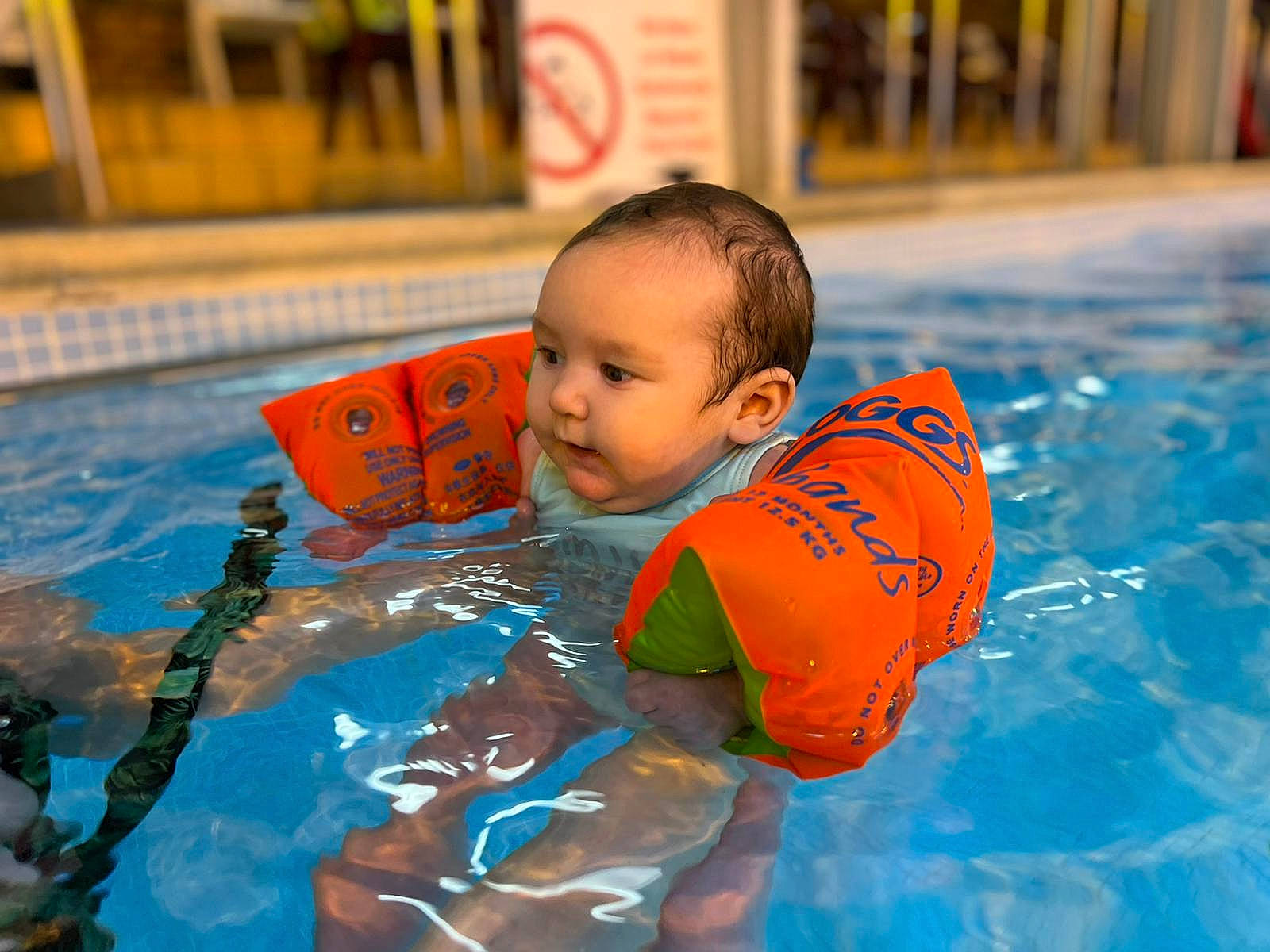 Elena is registered to the contest to win money with this photo: baby, baby_products, bathing, child, fun, games, happy, indoor_games_and_sports, leisure, leisure_centre, orange, outdoor_recreation, person, personal_protective_equipment, play, recreation, swimmer, swimming_pool, toddler, water