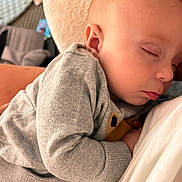 Charles is registered to the contest to win money with this photo: baby, sleeping, child, cozy, grey_sweater, person, closeup, nap, peaceful, infant, cute, soft, warm, indoor, resting, head, face, skin, comfort, hug