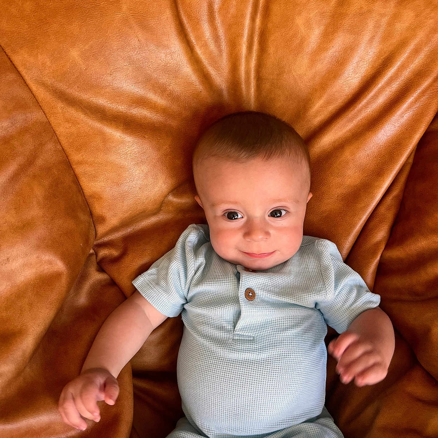 Charles is registered to the contest to win money with this photo: arms, baby, blue_outfit, child, clothing, comfortable, cozy, cute, furniture, happy, head, indoor, infant, leather_chair, portrait, seated, skin, smile, texture, young_child
