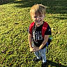 Denver is registered to the contest to win money with this photo: child, boy, grass, sunlight, backpack, jeans, tshirt, black_shoes, water_bottle, outdoor, smile, face, blond_hair, standing, yard, tree, shadow, playful, casual_clothing, daytime