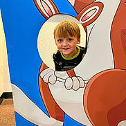 Denver joined the competition — help win amazing prizes! child, boy, face, smile, kangaroo, cutout, cartoon, blue_background, indoor, playful, young, peeking, happy, casual_clothing, short_hair, light_brown_hair, fun, portrait, cute, interactive