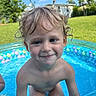 Eli is registered to the contest to win money with this photo: child, toddler, pool, water, summer, outdoor, smile, blue_eyes, curly_hair, inflatable_pool, grass, sky, sunny_day, play, bare_chest, happy, vacation, fun, nature, backyard