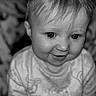 Angel is registered to the contest to win money with this photo: baby, black_and_white, child, closeup, clothing, cute, expression, eyes, face, hair, happy, head, indoors, infant, patterned_clothing, person, portrait, smile, soft_focus, young