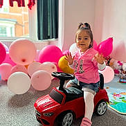 Ariana joined the competition — help win amazing prizes! balloons, birthday, carpet, celebration, child, curtains, happy, indoor, person, pink_clothing, pink_jersey, playtime, room, shorts, smiling, sneakers, toddler, toy_car, white_tights, window