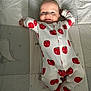 Caleb joined the competition — help win amazing prizes! baby, infant, smiling, onesie, strawberry_print, quilted_blanket, dumbo, cartoon, lying_down, arms_stretched, cute, child, bedroom, soft_lighting, happy, face, head, footed_pajamas, cozy, portrait