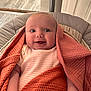 Nevaeh-Leigh is registered to the contest to win money with this photo: baby, infant, blanket, orange_blanket, knit_blanket, smile, tongue_out, cushion, seat, striped_onesie, onesie, indoor, wood_floor, door, happy, cute, child, person, face, head