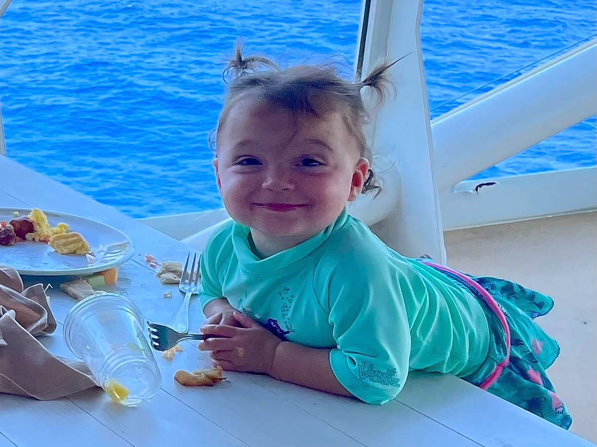 Delilah is registered to the contest to win money with this photo: aqua, azure, baby, baby_toddler_clothing, child, event, food, fun, happy, joy, lake, leisure, person, plate, recreation, smile, summer, table, tableware, toddler