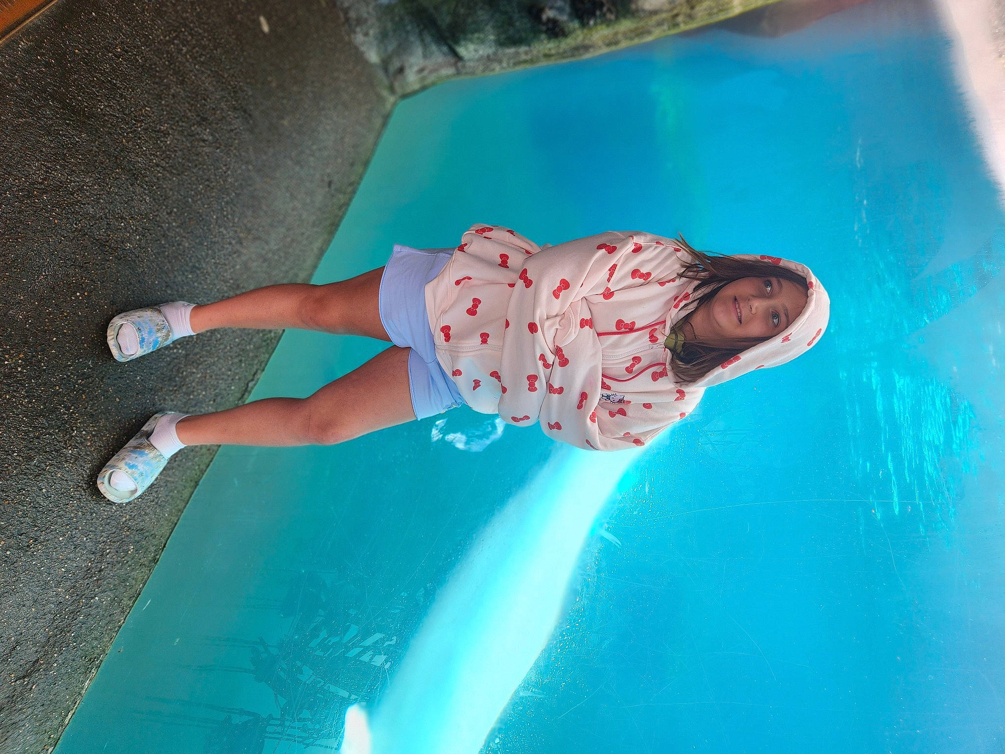 Brianne is registered to the contest to win money with this photo: azure, barefoot, bathing, child, electric_blue, foot, fun, happy, headwear, human_leg, joy, knee, leg, leisure, person, play, recreation, shorts, swimming_pool, thigh