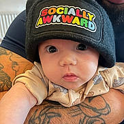 Nia-Marie joined the competition — help win amazing prizes! baby, infant, beanie, hat, tattoo, arm, closeup, person, child, cute, clothing, pattern, face, eyes, expression, indoor, adult, holding, skin, portrait