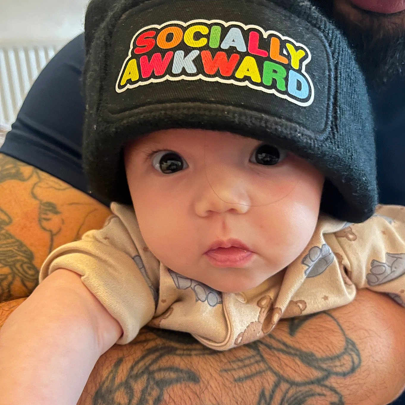 Nia-Marie joined the competition — help win amazing prizes! adult, arm, baby, beanie, child, closeup, clothing, cute, expression, eyes, face, hat, holding, indoor, infant, pattern, person, portrait, skin, tattoo