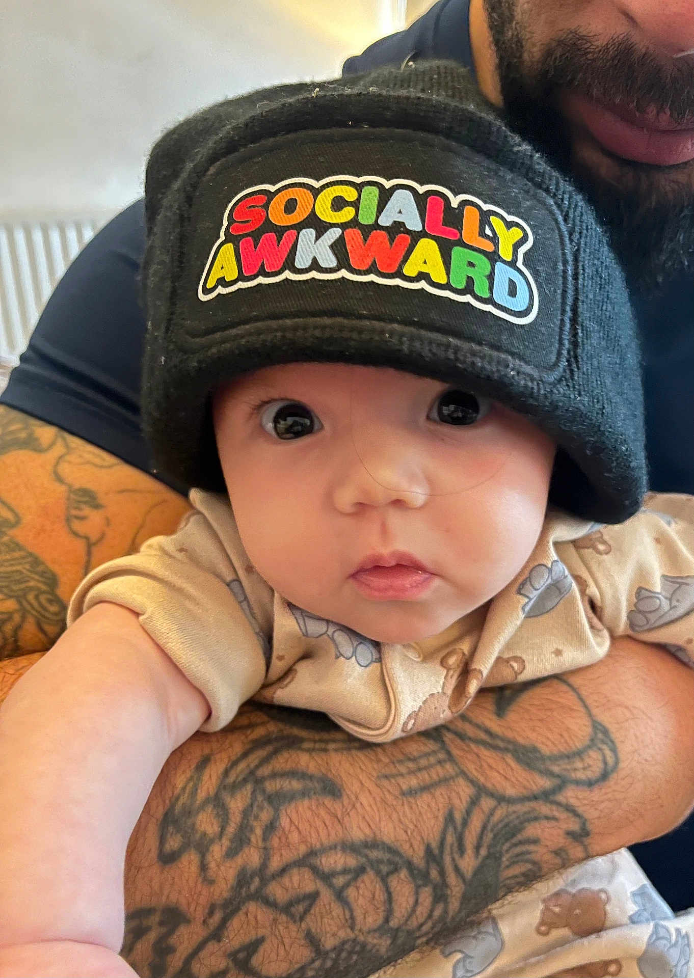 Nia-Marie joined the competition — help win amazing prizes! baby, infant, beanie, hat, tattoo, arm, closeup, person, child, cute, clothing, pattern, face, eyes, expression, indoor, adult, holding, skin, portrait