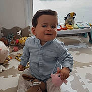 Maël a rejoint le concours — aidez-le/la à gagner de superbes lots ! toddler, child, smiling, indoor, toy, stuffed_animal, puzzle_mat, socks, buttoned_shirt, striped_pants, face, happy, playtime, window, daylight, floor, baby_toys, colorful, cute, young_child