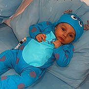 Joseph a rejoint le concours — aidez-le/la à gagner de superbes lots ! baby, infant, blue_onesie, hat, monster_costume, couch, pillows, blanket, indoor, child, cute, adorable, relaxed, lying_down, looking_at_camera, black_hearts, soft_lighting, cozy, home, portrait