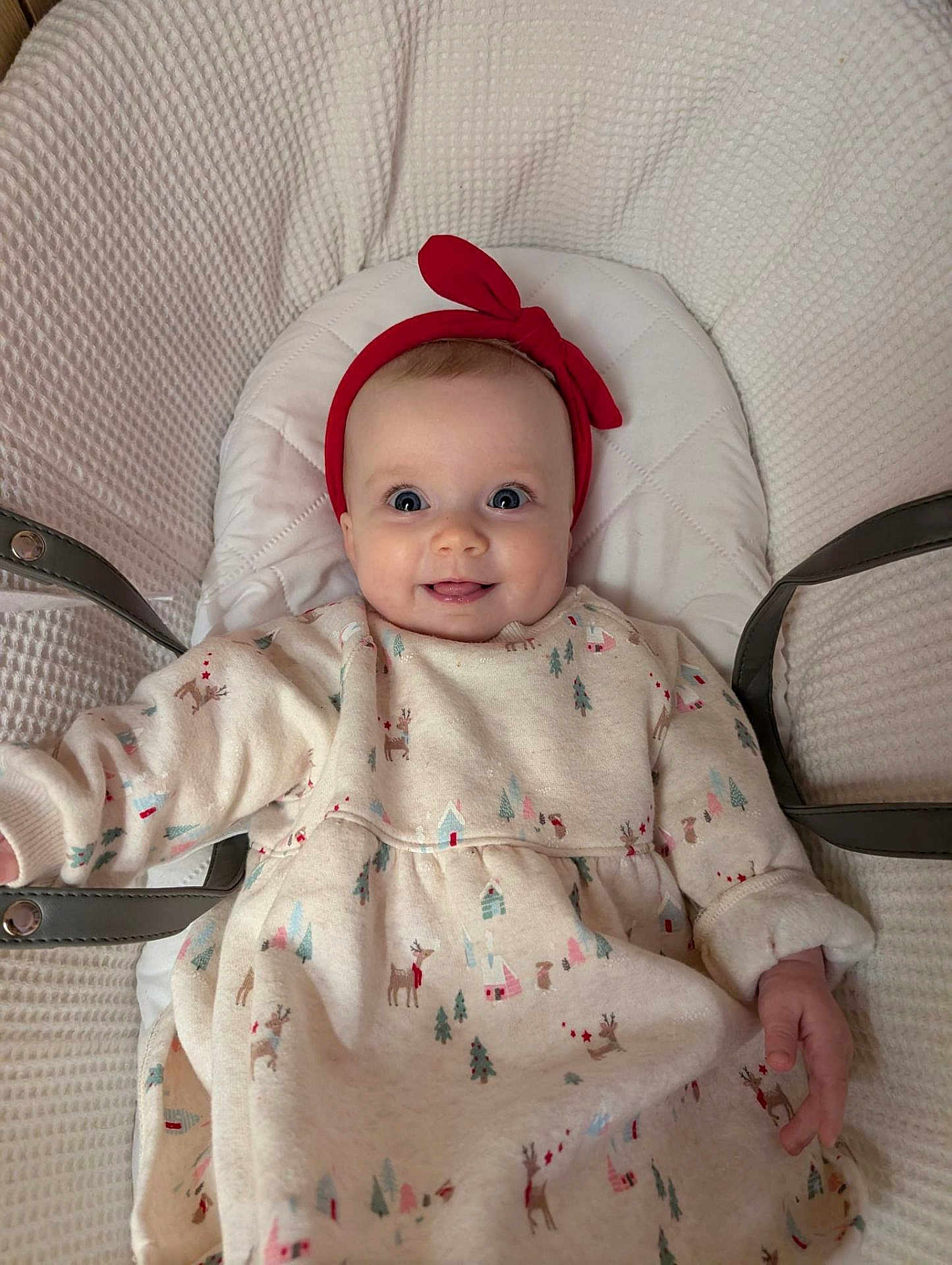 Rosie is registered to the contest to win money with this photo: baby, infant, smile, headband, red, dress, patterned_clothing, cushion, seat, cozy, happy, child, cute, indoor, portrait, person, apparel, warm, comfort, young