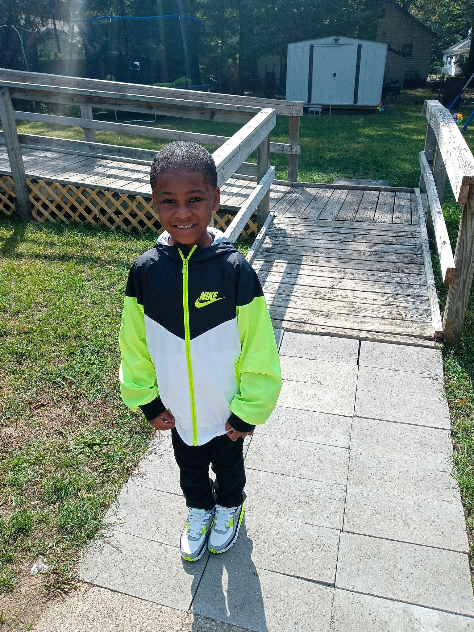 Treyvon joined the competition — help win amazing prizes! asphalt, child, fence, fun, grass, joy, leisure, pattern, pedestrian, people_in_nature, person, personal_protective_equipment, plant, play, recreation, sleeve, smile, sports_equipment, sweatpant, toddler