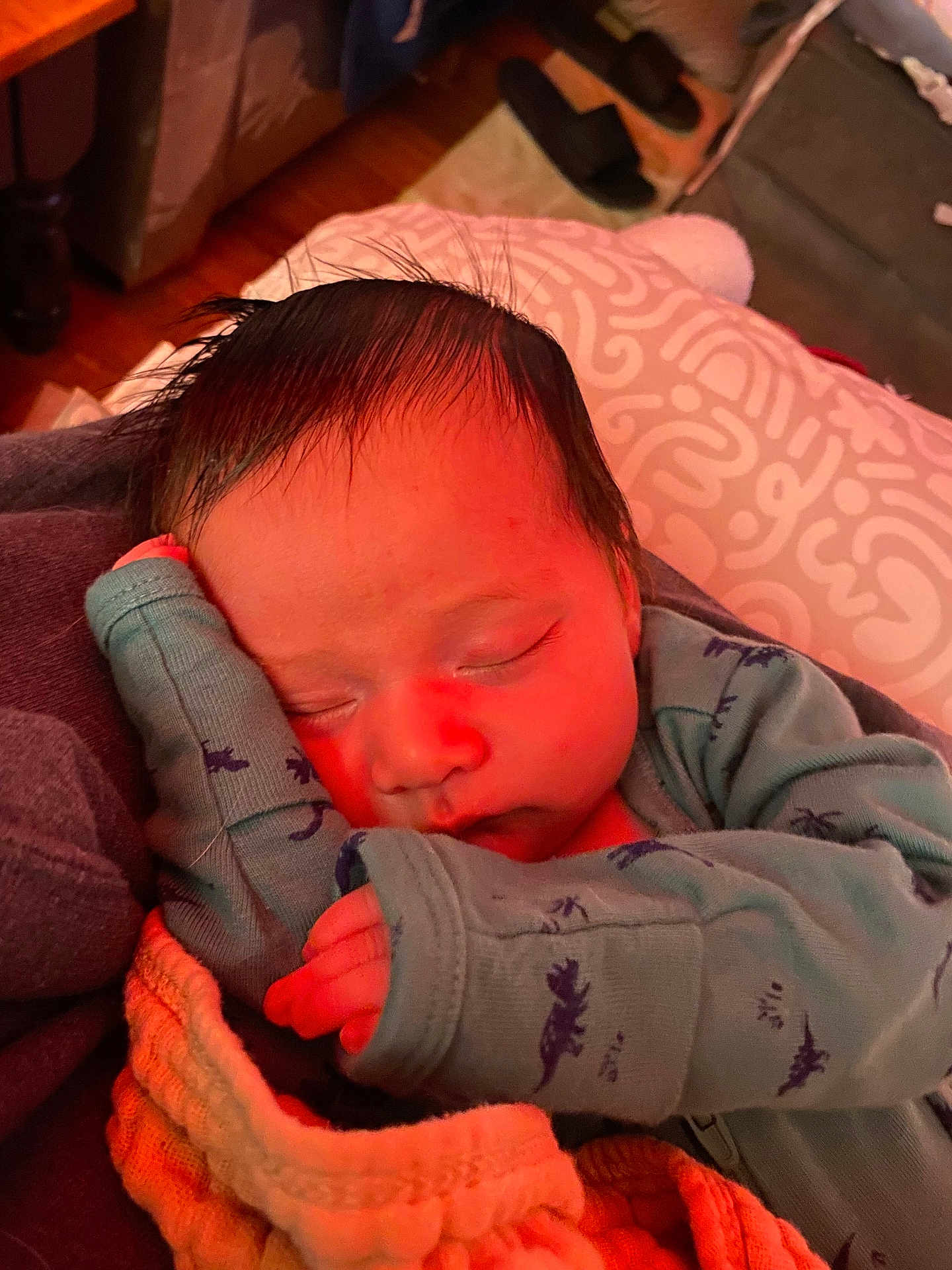 Hugo is registered to the contest to win money with this photo: baby, sleeping, newborn, infant, clothing, blanket, hand, face, peaceful, cozy, indoors, portrait, cute, resting, soft_light, warm_tone, dinosaur_print, young_child, human, sleep