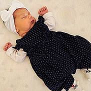 Athena joined the competition — help win amazing prizes! baby, newborn, sleeping, dress, polka_dot, headband, bow, white, navy_blue, blanket, infant, cute, peaceful, lying_down, clothing, soft, child, portrait, indoors, resting