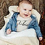baby, child, smiling, denim_jacket, knit_blanket, tree_trunk, autumn_leaves, outdoor, happy, portrait, cute, warm_clothing, infant, nature, fall, baby_clothes, face, person, sitting, cozy