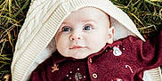 Tobie is registered to the contest to win money with this photo: baby, infant, knit_blanket, maroon_sweater, holiday_clothing, grass, outdoor, cute, portrait, child, winter_wear, festive, face, blue_eyes, soft_light, cozy, nature, hand, laying_down, warm_clothing