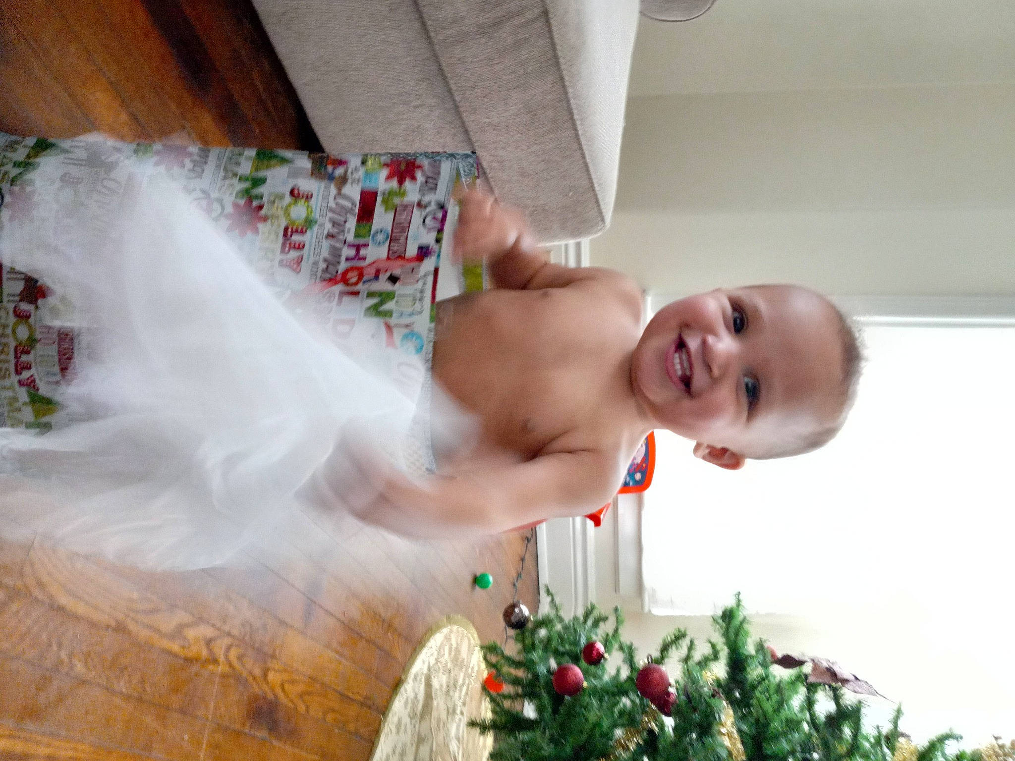 Jalen is registered to the contest to win money with this photo: abdomen, baby, child, christmas, dress, event, finger, flooring, fun, grass, happy, holiday, joy, leisure, ornament, person, room, smile, toddler, trunk