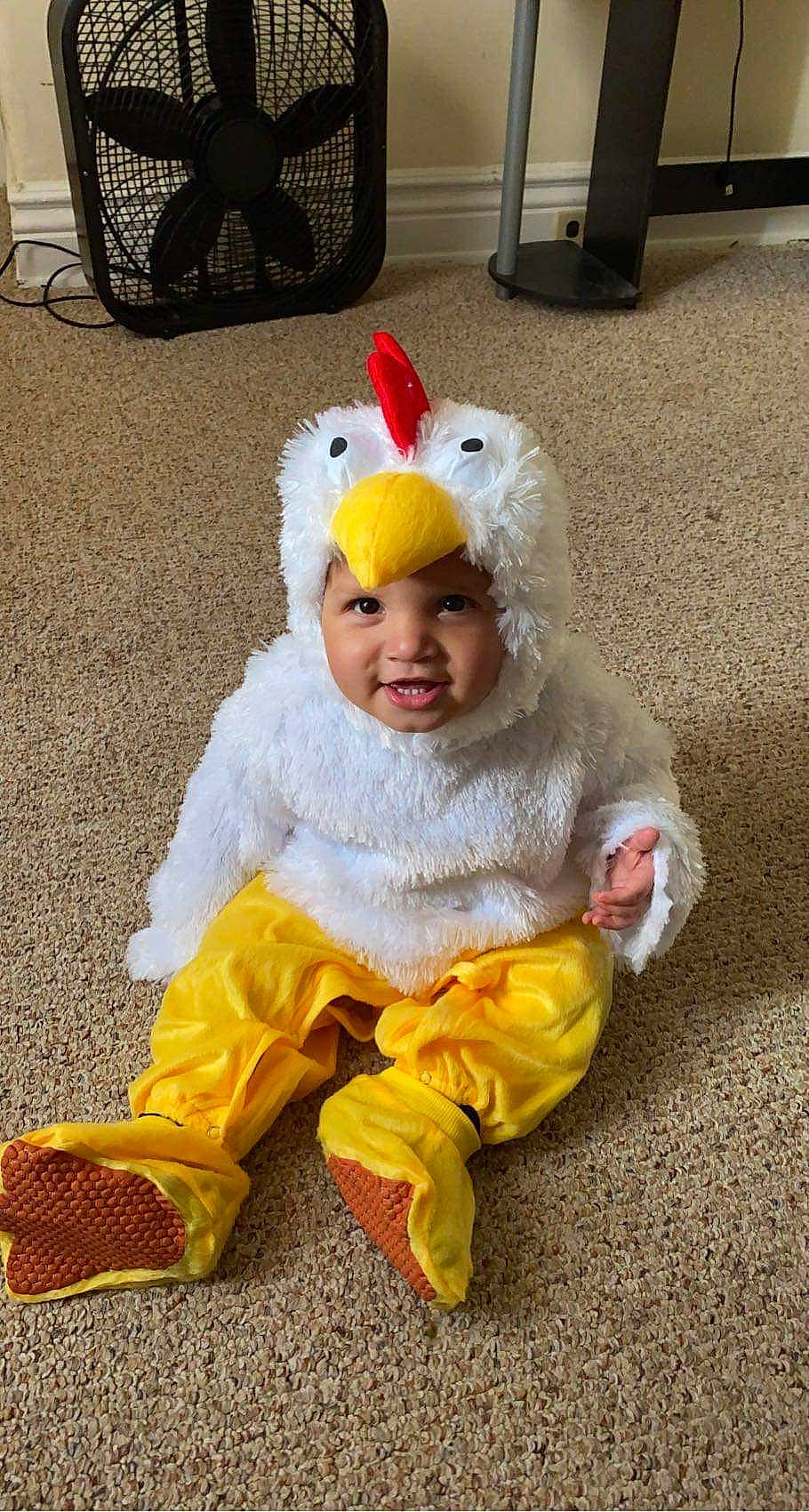 Jalen is registered to the contest to win money with this photo: asphalt, baby, baby_products, cap, costume, costume_hat, event, eye, fictional_character, fun, fur, fur_clothing, happy, headwear, mammal, mascot, person, sitting, smile, toddler