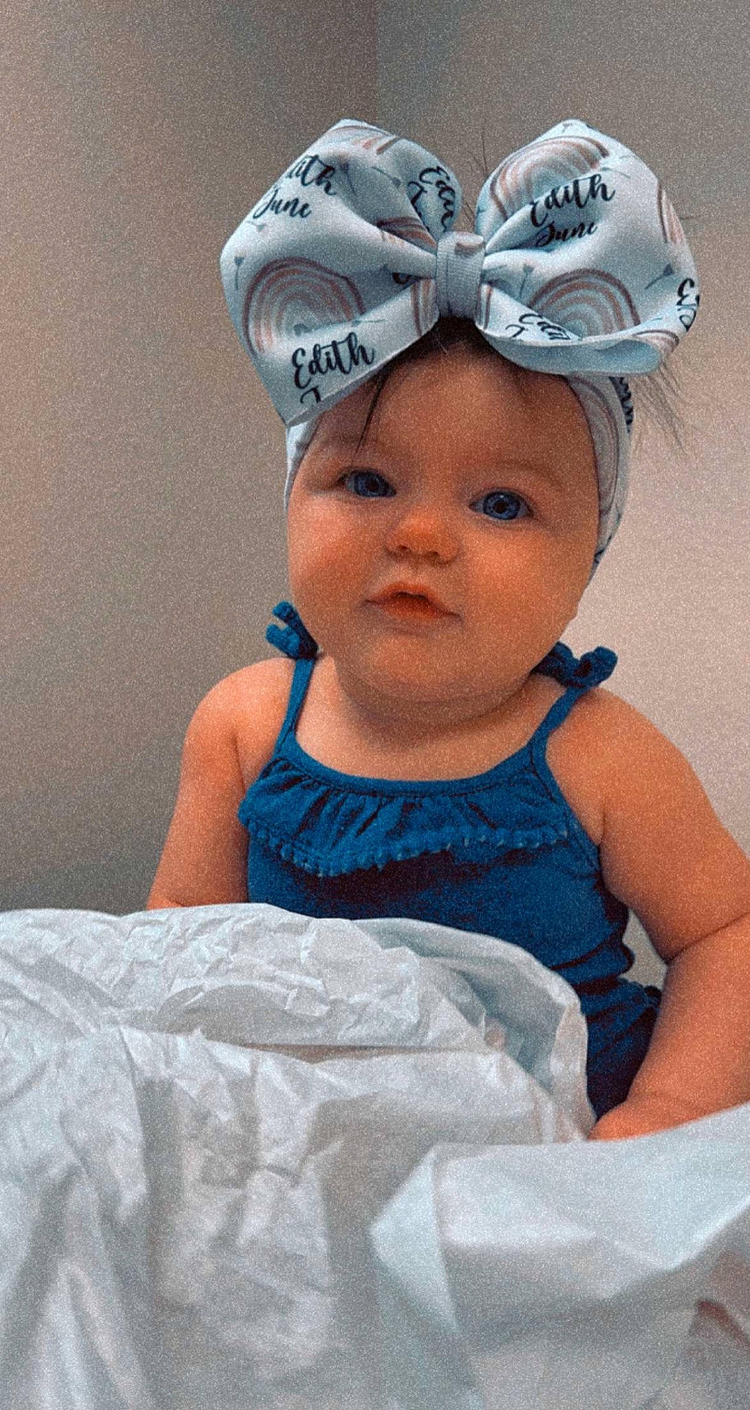 Edith is registered to the contest to win money with this photo: aqua, baby, baby_toddler_clothing, cap, child, electric_blue, eye, face, fun, happy, head, headband, headgear, headpiece, headwear, iris, person, personal_protective_equipment, pink, sleeve