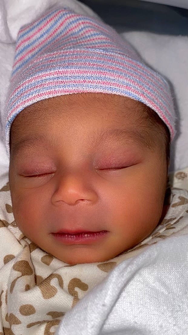 Shyne is registered to the contest to win money with this photo: baby, cap, cheek, chin, eye, eyebrow, eyelash, finger, forehead, hairstyle, hand, headwear, human_body, lip, mouth, neck, nose, person, pink, skin