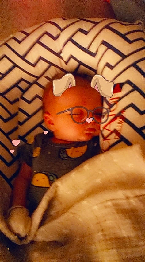 Loki is registered to the contest to win money with this photo: baby, cheek, chest, child, comfort, eyewear, fun, gesture, glasses, mouth, nail, orange, pattern, person, personal_protective_equipment, room, thumb, toddler, toy, vision_care