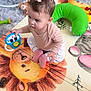 Sophia Lana joined the competition — help win amazing prizes! baby, child, girl, toy, play_mat, lion, mouse, pink_socks, bow, carpet, green_pillow, indoor, cute, curious, sitting, soft_lighting, earrings, clothing, floor, playtime