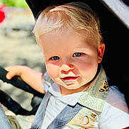 Camille a rejoint le concours — aidez-le/la à gagner de superbes lots ! child, toddler, baby, blond_hair, blue_eyes, stroller, safety_strap, sunlight, outdoor, cute, portrait, baby_clothes, smile, closeup, daylight, seatbelt, infant, happy, person, baby_face